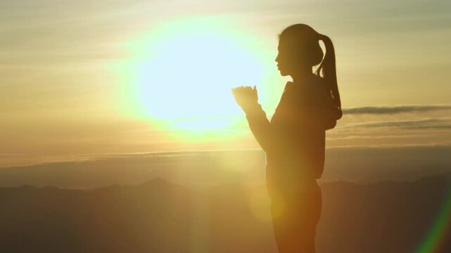 Silhouette of Religious young woman praying to God in the morning, spirtuality and religion,  Christians and Bible study concept.