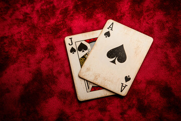 Obraz premium Vintage Playing Cards: Ace and Jack of Spades on Red Velvet