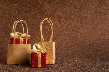 Christmas gifts in red paper with gold ribbon and bags. On a brown shiny background. Christmas Sales, New Year 2025