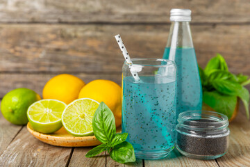 Diet detox cocktail with basil and chia seeds in a glass jar and a glass on a textured background....