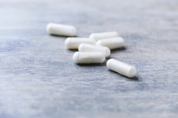 Beta-alanine capsules. Bodybuilding food supplements on wooden background. Soft focus. Close up. Copy space.	