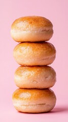 Tower of pierishki stacked high on a light pink background Rustic, homemade aesthetic with soft golden crust 