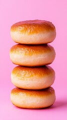 Traditional Russian pierishki with golden crust arranged in a stack on a soft pink background Perfect for recipe or cultural food concept 