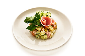 A plate of food with a ham and cucumber on it