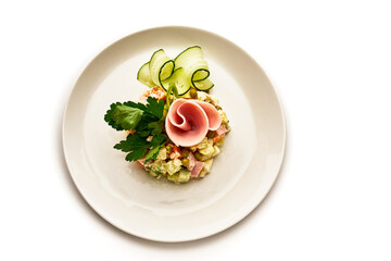 A plate of food with a ham and cucumber on it