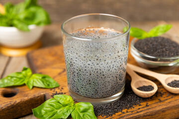 Basil seeds on textured wooden background. Close-up. Superfood. Ocimum basilicum. Organic basil seeds. selasih. Space for text. Copy space.
