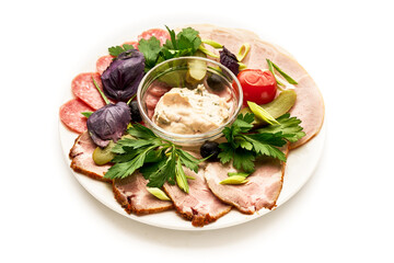 A plate of food with a variety of meats and vegetables, including tomatoes
