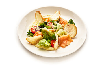 A plate of food with a variety of ingredients including lettuce, tomatoes