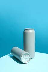 Two gray aluminum beverage cans for soda, beer, energy drinks, against vibrant blue background, creating minimalist and modern composition. Fresh and vibrant aesthetic for drink branding. Mockup