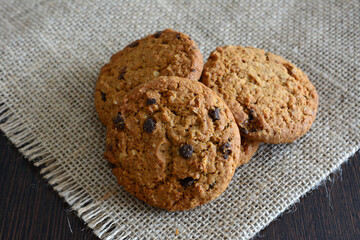 oatmeal cookies with chocolate chips on the burlap texture on the table
