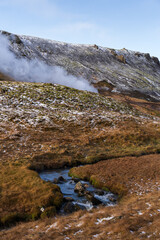 Obraz premium Scenic view of the Reykjadalur hot springs area, with a hot stream flowing through a picturesque valley