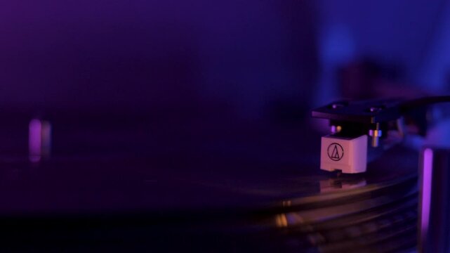 Close Up Of A Vinyl Record Player Spinning With Cinematic Purple And Blue Lighting