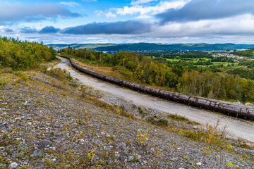 A panorama view looking down onto a leaking wooden-stave water pipe above Corner Brook in...