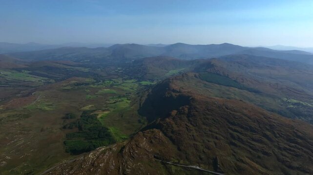 Caha Pass, County Cork, Ireland, September 2024. Drone pulls backwards in a panoramic overview and gradual descent offering a sweeping view of the mountain road along the border with County Kerry.