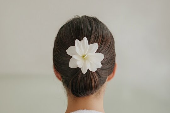 Minimalist back view of woman with white flower.