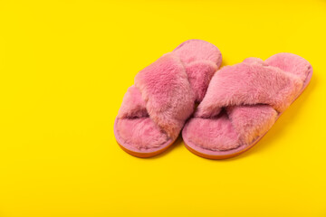 Soft slippers on a bright colored background, close-up. House slippers. Comfortable shoes for home. Foot care concept. Home comfort. Space for text. Copy space.