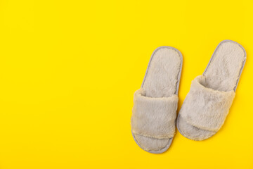 Soft slippers on a bright colored background, close-up. House slippers. Comfortable shoes for home. Foot care concept. Home comfort. Space for text. Copy space.