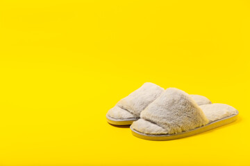 Soft slippers on a bright colored background, close-up. House slippers. Comfortable shoes for home. Foot care concept. Home comfort. Space for text. Copy space.