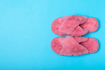 Soft slippers on a bright colored background, close-up. House slippers. Comfortable shoes for home. Foot care concept. Home comfort. Space for text. Copy space.