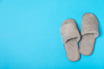 Soft slippers on a bright colored background, close-up. House slippers. Comfortable shoes for home. Foot care concept. Home comfort. Space for text. Copy space.