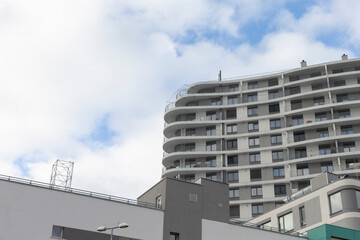 This stunning apartment complex features a unique curved facade that stands out against the cloudy sky