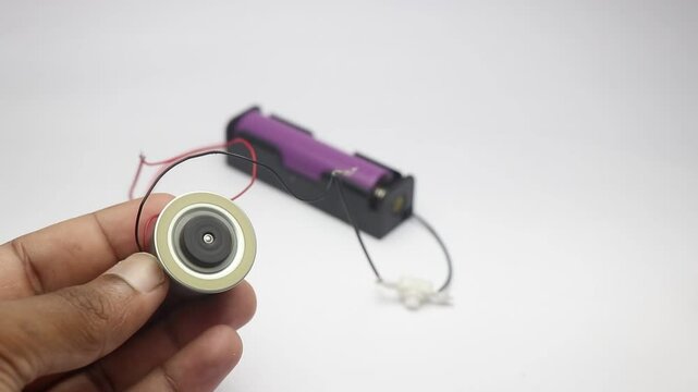 Small dc motor connected to battery with switch in between these components. DC motor found in cd and dvd writers working when power is given