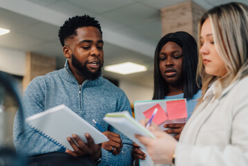 University students collaborating and brainstorming ideas in library