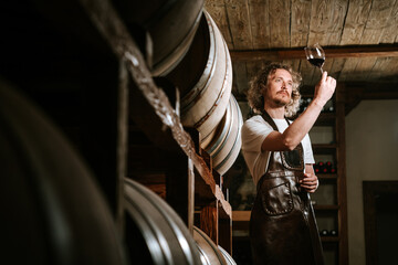 Winemaker Inspecting Red Wine in Cellar