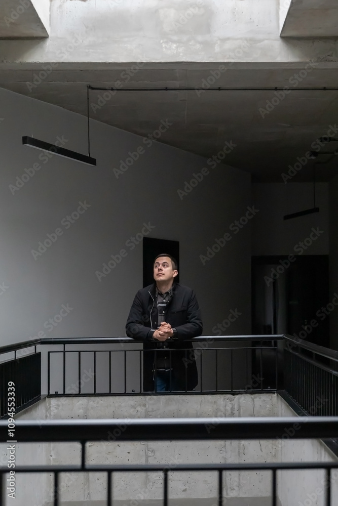 Wall mural man in black jacket in modern corridor