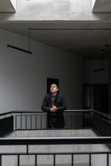 man in black jacket in modern corridor