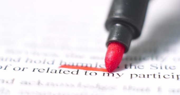 Close-up of red marker tip highlighting printed black text on white paper, emphasizing precision and clarity. Represents education, office work, legal annotation, proofreading, and document organizat
