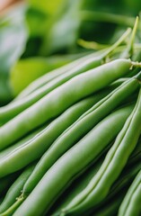 Fototapeta premium Fresh green beans and leafy greens arranged on a dark stone surface in a kitchen setting