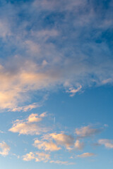 Bright blue sky with golden fluffy clouds