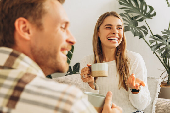 Happy attractive smiling couple woman and man drinking together coffee, having coffee break, talking