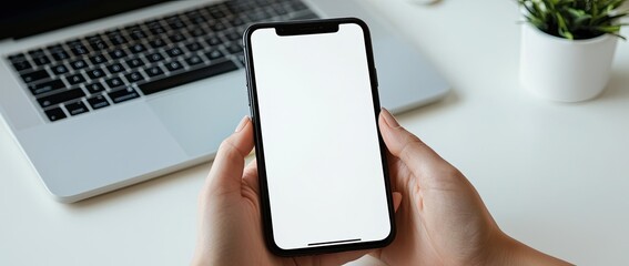 Close-up of a woman's hands using a mobile phone and laptop on a white desk, a panoramic banner with a copy space area for an online work or remote working concept