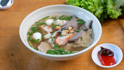 Egg noodles with pork wonton soup or pork dumplings soup and vegetable isolated. Chinese egg noodle topping slice roasted pork and wontons