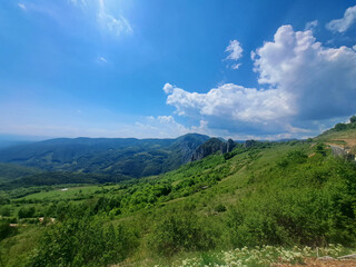 Naklejka premium Nature landscape of green hills and cloudy blue sky