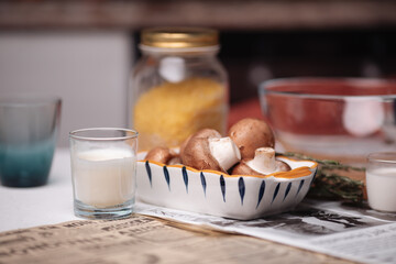A woman is going to cook, food is on the table: mushrooms, a bowl, cream