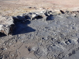 boiling mud in Sol de Manana, Bolivia. Geothermal volcanic activity. Mudpot close up with boiling and bubbling mud, and cracked earth