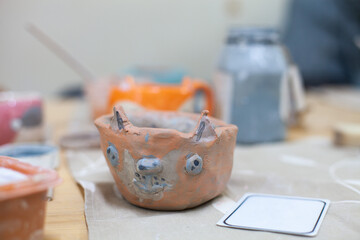 Cute squirrel cup made from clay by child. Children's workshop at pottery studio. Creating ceramics with own hands.