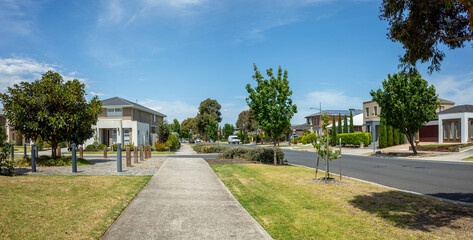 Panoramic view of a modern suburban neighborhood with contemporary houses, wide footpath, and landscaped street. Well-maintained residential neighborhood in Australia.