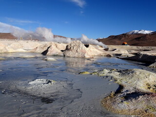 Sol de manana, volcanic area and geothermal park with boiling mud pots and gas fuming from craters in the altiplano of Bolivia, South america. Panorama landscape