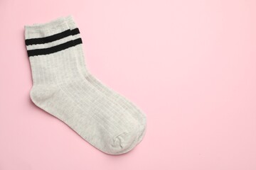 Pair of soft comfortable socks on light pink background, top view. Space for text