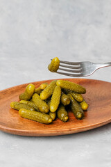 Fork with pickled cucumbers on neutral background