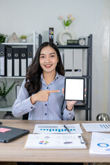 Asian businesswoman holding a digital tablet with a blank screen in her office