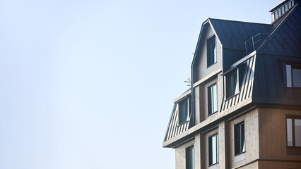 Wall of commercial building with large windows and Exterior porcelain cladding ventilated panels. Fragment of building over blue sky with copyspace 16x9 shot.