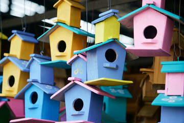 Colorful Birdhouses Hanging in a Market Display, Showcasing Vibrant Wooden Designs in Various...