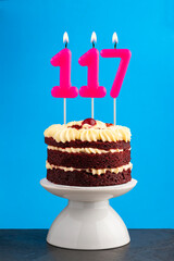 Red velvet birthday cake with number 117 candle