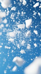 White snow particles flying against a vibrant blue sky