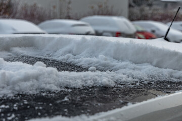 A woman clears snow from her car before leaving for work